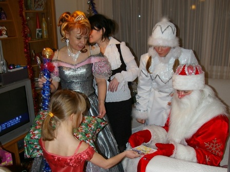 Фото. Девочка дарит рисунок Деду Морозу.